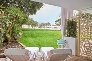 a patio with two chairs and a lawn at The Nici in Bournemouth