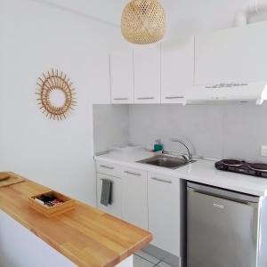 a white kitchen with white cabinets and a sink at Villa Thalassa Apartments in Pefkohori