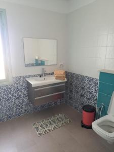 ein Bad mit einem Waschbecken und einem WC in der Unterkunft villa izabelles in Djerba