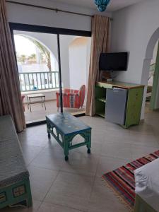 a living room with a table and a tv at villa izabelles in Djerba