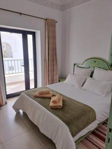 a bedroom with a bed with two slippers on it at villa izabelles in Djerba