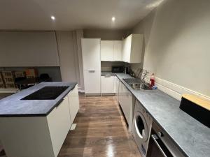 a kitchen with white cabinets and a counter top at Beautiful 1-Bed Apartment in Liverpool in Liverpool