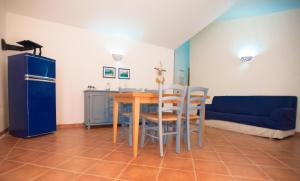 cocina y comedor con mesa y sillas en Hotel Club Baia delle Mimose, en Badesi