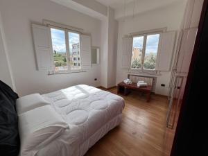 a bedroom with a white bed and two windows at La Piazzetta in Avellino