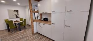 a kitchen with white cabinets and a table with green chairs at Gemütliche 3 1/2 Zimmer Wohnung in Ludwigsburg