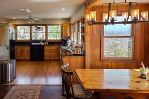 cocina con mesa de madera y suelo de madera en Smoky Mountain Vista en Tallassee