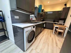 a kitchen with a washing machine and a sink at Charming Duplex 10min to London Bridge Quiet in London