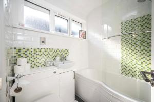 y baño blanco con lavabo, bañera y lavamanos. en Pass the Keys Modern Beckenham Apartment fast London train links en Londres