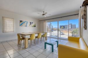 a dining room with a table and yellow chairs at Blue Bay #419 in Cabo San Lucas