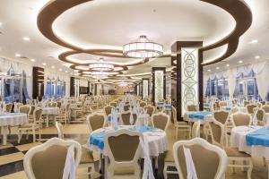 a banquet hall with white tables and chairs and chandeliers at Sun Star Resort Hotel in Alanya