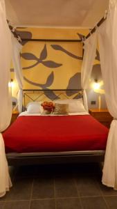 a bedroom with a red bed with white curtains at Agriturismo La Buona Compagnia in Iesi