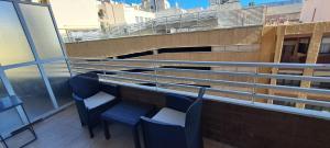 a balcony with two chairs and a view of a building at APART HOTEL in Alicante