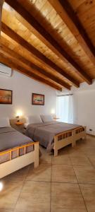 a large bedroom with two beds and wooden ceilings at B&B L'Antica Torre in Pozzallo