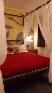 - une chambre avec un lit rouge à baldaquin dans l'établissement Agriturismo La Buona Compagnia, à Jesi