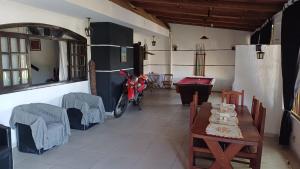 una moto parcheggiata in una stanza con tavolo e sedie di Home Pousada Residence a Curitiba