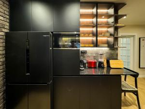 a kitchen with black cabinets and a black refrigerator at Momentum in Belgrade