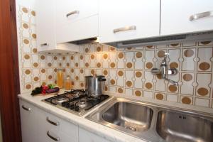 a kitchen with a sink and a pot on a stove at Mughetto in Bibione +5 photos