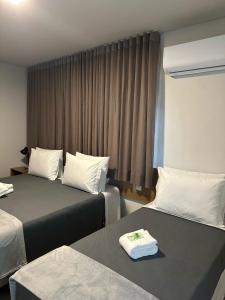 Cette chambre comprend 2 lits et une fenêtre. dans l'établissement Hotel Cabana, à Caetanópolis