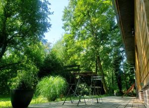 a porch with chairs and a table and trees at La petite forêt in Mons-Boubert