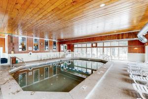 a swimming pool in a building with chairs around it at 6B The Seasons in Bartlett