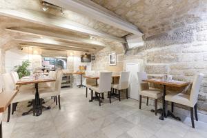 فندق دو ليمان في باريس: مطعم بطاولات وكراسي وجدار حجري