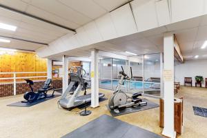 a gym with treadmills ellipticals and a pool at 6B The Seasons in Bartlett