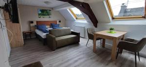 een woonkamer met een bed en een tafel bij Pension am Lieserpfad in Manderscheid