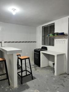 een keuken met een fornuis en 2 krukken. bij Mi fe apartamento in Esquipulas