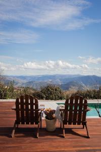 duas cadeiras sentadas ao lado de uma mesa e uma piscina em Casa do Santo - Wine & Tourism em Provesende