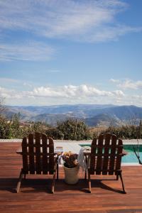 two chairs sitting next to a table and a pool at Casa do Santo - Wine & Tourism in Provesende