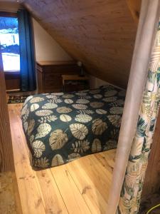 ein Schlafzimmer mit einem Bett mit einer schwarzen und weißen Decke in der Unterkunft Au croque nature in Soultzeren