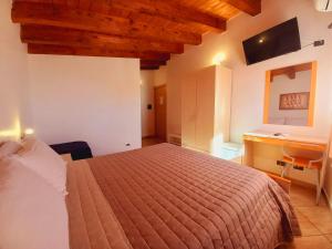 1 dormitorio con cama, escritorio y lavamanos en B&B L'Antica Torre, en Pozzallo