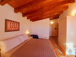 una camera con letto in una stanza con soffitti in legno di B&B L'Antica Torre a Pozzallo