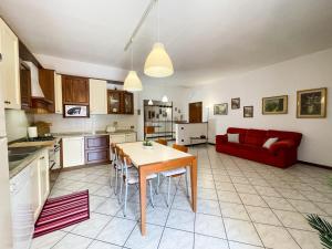 a kitchen and living room with a table and a red couch at Torre Apartment - Affitti Brevi Italia in Modena