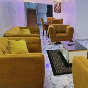 - un salon avec des canapés, des chaises et une table dans l'établissement S&A Lump Apartments, Enugu, Nigeria, à Enugu