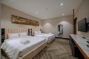 a hotel room with two beds and a flat screen tv at La Beaute Hotel - Quy Nhơn in Quy Nhon +92 photos
