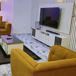 - un salon avec un canapé et une télévision dans l'établissement S&A Lump Apartments, Enugu, Nigeria, à Enugu