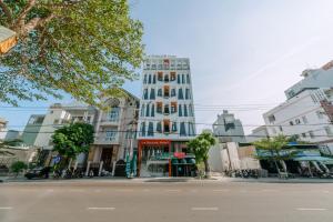 a tall white building on a city street at La Beaute Hotel - Quy Nhơn in Quy Nhon