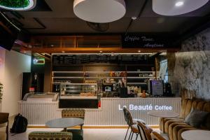 a restaurant with a counter with chairs and a table at La Beaute Hotel - Quy Nhơn in Quy Nhon