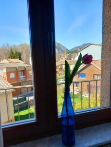 een blauwe vaas met een bloem in een raam bij HOTEL RURAL ORQUIDEA in Velilla del Río Carrión