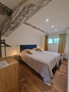 a bedroom with a large bed and a wooden floor at Domaine du Mas Foucray in Les Baux-de-Provence