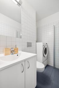 Un baño blanco con inodoro y lavabo. en Seaside Apartment with Central Location in Oslo City Center, en Oslo