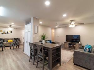ein Wohnzimmer mit einem Tisch, einem Sofa und einem TV in der Unterkunft Chic & Spacious 3br2ba Home In Pecan Lake in Little Rock