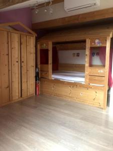ein großes Etagenbett aus Holz in einem Zimmer in der Unterkunft Ambiance Authentique coté gare in Ambérieu-en-Bugey
