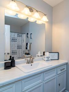 a bathroom with a sink and a large mirror at Chic & Spacious 3br2ba Home In Pecan Lake in Little Rock