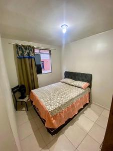 een slaapkamer met een bed en een raam bij Apt. Mello 2/4, wifi, piscina. in Ananindeua