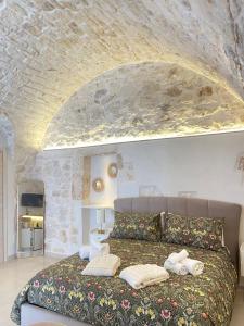 una camera da letto con un grande letto e un muro in pietra di Eureka luxury room a Ostuni