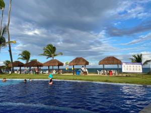 uma piscina num resort com pessoas na água em Ancorar Flats Condomínio à Beira Mar em Porto de Galinhas