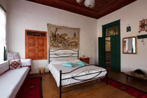 - une chambre avec un lit et un canapé dans l'établissement GuestHouse 1805, à Gjirokastër