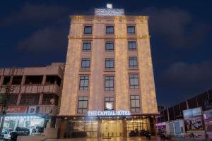 un palazzo alto con luci accese di notte di Monday Hotels Swarna's The Capital a Vijayawāda